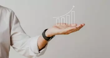 Mão segurando gráfico de crescimento representando excelência em contabilidade