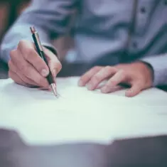 Mão assinando documento para abertura de empresa com suporte contábil em São Paulo